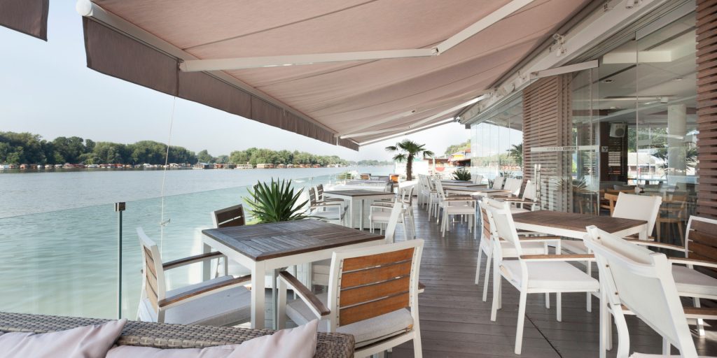 Riverside terrace cafe with awning covering seating area