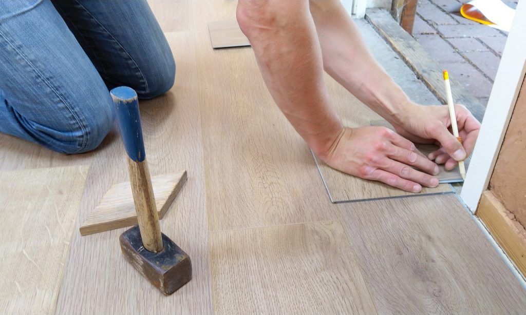 Measuring a floor for cutting an LVT tile.